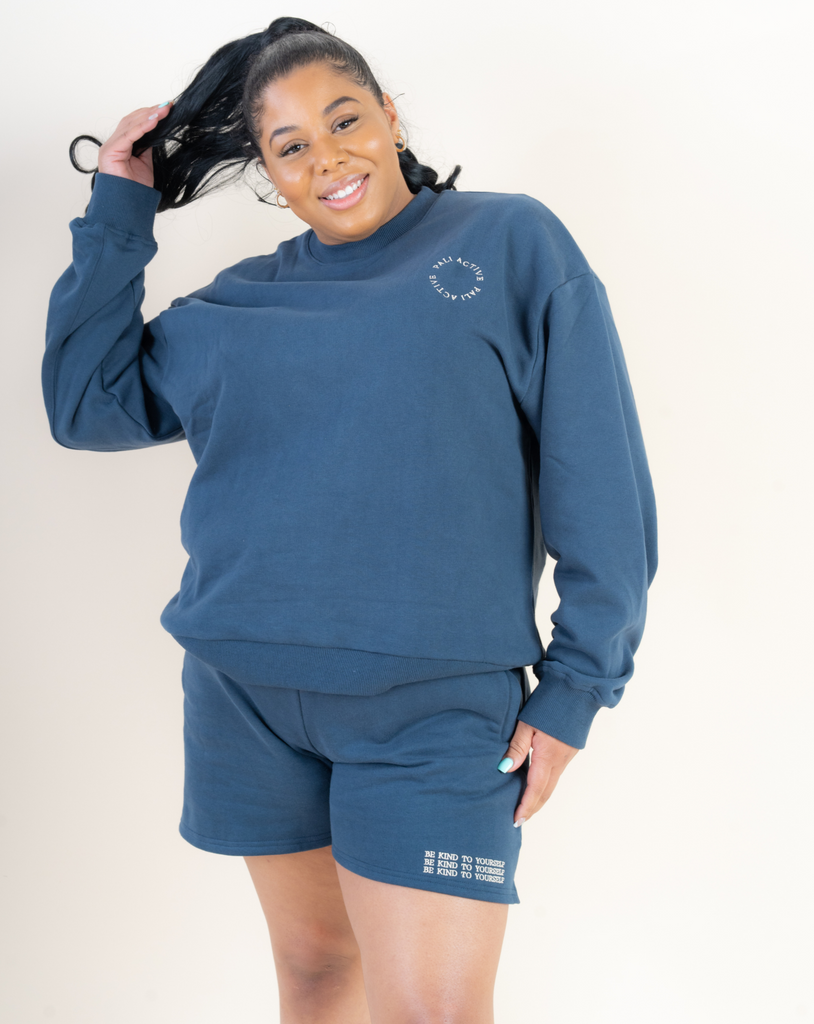 Model wearing a beautiful blue pullover and sweat shorts set with an affirmation be kind to yourself